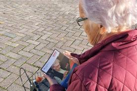 Seniorin steht auf dem Marktplatz in Ratzeburg und bl&auml;ttert im Buch