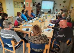 Die Teilnehmenden sitzen im Raum und schauen zur Pr&auml;sentation an der Wand