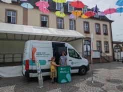 Eine Besucherin steht vor dem Infomobil und unterh&auml;lt sich mit unserem Referenten