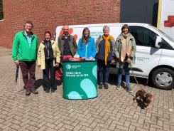 Sechs Personen und ein Hund stehen am Info-Mobil und l&auml;cheln in die Kamera. In der Mitte steht Referentin Petra. Links Diakon Frank Peters und Pastorin Katharina Riemer und rechts von ihr Diakonin Silke Langer. Der Hund hei&szlig;t Josef.
