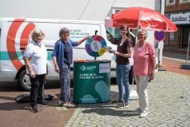 Drei Mitglieder des SeniorInnenbeirats Harsefeld stehen mit Petra am Info-Stand vor dem Info-Mobil und l&auml;cheln in die Kamera.