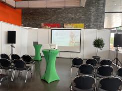 Die Titelfolie der Pr&auml;sentation sowie einige St&uuml;hle und zwei Stehtische sind in der Oberrheinhalle in Offenburg zu sehen.