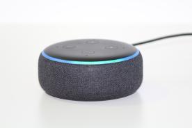 Ein runder Lautsprecher mit Alexa ist in einem wei&szlig;en Raum mittig platziert
