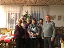 Vier Teilnehmerinnen und zwei Teilnehmer stehen vor einem Tannenbaum im Ortwiger Gemeindezentrum und l&auml;cheln in die Kamera.