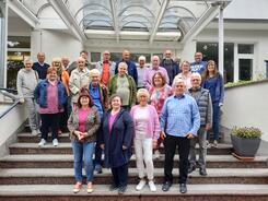 Ein Gruppenbild der rund 25 Teilnehmenden vor dem Geb&auml;ude der politischen Bildungsst&auml;tte Helmstedt. Die Senior:innen mit Petra (rechts) stehen auf einer Treppe.