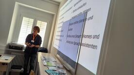 Referent Johannes steht vor einer auf die Wand projizierten Pr&auml;sentation 