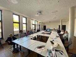 In einem Raum im Pattensener Rathaus sitzen &uuml;ber zehn Menschen an verschiedenen Tischen verteilt.