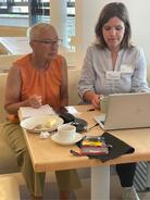 Digitalexpertin Theresa zeigt einer &auml;lteren Besucherin Dinge am Laptop.
