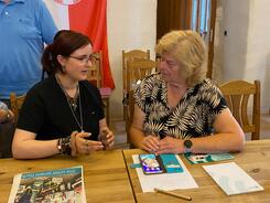 Sch&uuml;lerin Emma (links) unterh&auml;lt sich mit einer Seniorin (rechts) an einem Tisch.