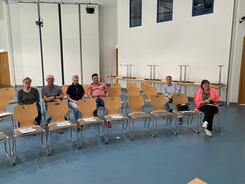 In einem gro&szlig;en Veranstaltungssaal im Rathaus Wiedemar sitzen sechs Personen auf zwei Stuhlreihen und blicken nach vorne in die Kamera.