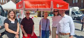 Theresa, zwei Mitarbeiterinnen von dem Familienb&uuml;ndnis, der B&uuml;rgermeister sowie eine &auml;ltere Besucherin stehen am Infostand.