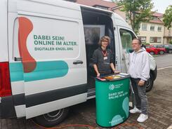 Ein Mann steht neben Mobilreferent Johannes vor dem Infomobil.