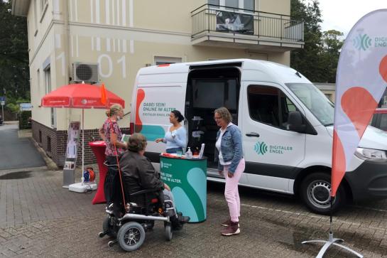 Infomobil Digitaler Engel in Oldenburg unterh&auml;lt sich mit einer Seniorin am Stand