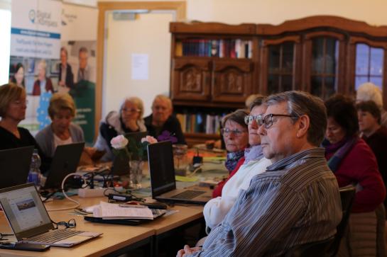 Die Teilnehmenden sitzen im Raum und schauen zur Pr&auml;sentation an der Wand