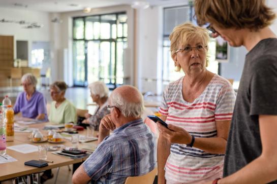 Eine Teilnehmerin unterh&auml;lt sich mit unserem Referenten und zeigt etwas auf ihrem Smartphone