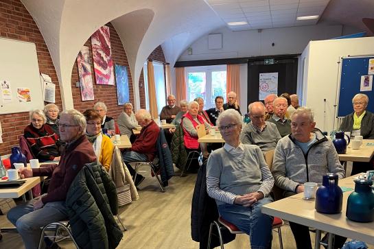 Die Teilnehmenden sitzen im Raum und schauen zur Pr&auml;sentation an der Wand