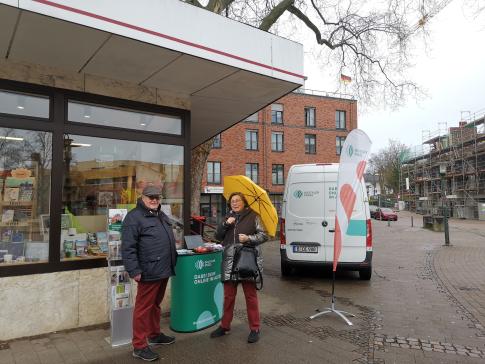 Eine Besucherin steht am Infostand und unterh&auml;lt sich mit Herrn Winner