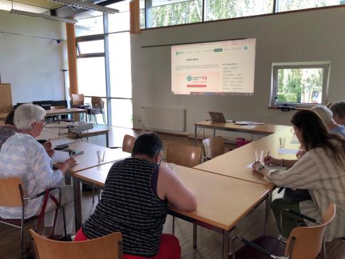 Teilnehmende der Veranstaltung sind von hinten zu sehen. Sie f&uuml;llen die Evaluation aus. Im Hintergrund sieht man die Internetseite des Digitalen Engel.