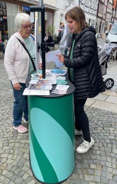 Theresa fragt an unserem Stand einer Seniorin eine Frage aus dem DiF&uuml;, nachdem sie am Gl&uuml;cksrad gedreht hat.