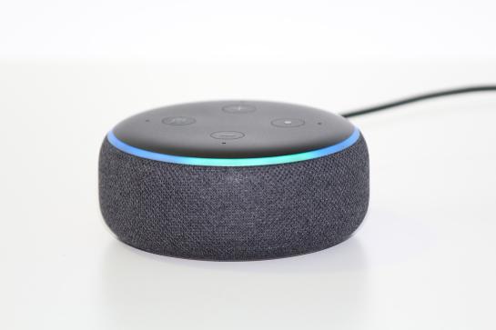 Ein runder Lautsprecher mit Alexa ist in einem wei&szlig;en Raum mittig platziert