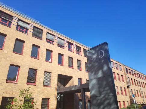 Blick auf ein Geb&auml;ude mit vielen Fenstern mit einem grauen Schild im Vordergrund mit der Aufschrift Rhein-Erft-Kreis