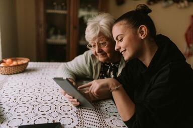 junges M&auml;dchen und &auml;ltere Frau gucken auf ein Tablet